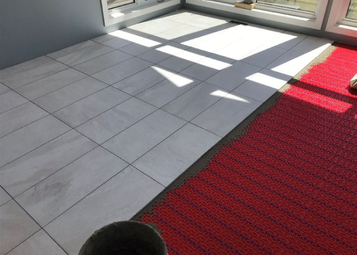 A warmup radiant heating system being installed on a subfloor with under slab insulation